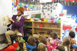 Image of a  SCITT student reading to a group of children